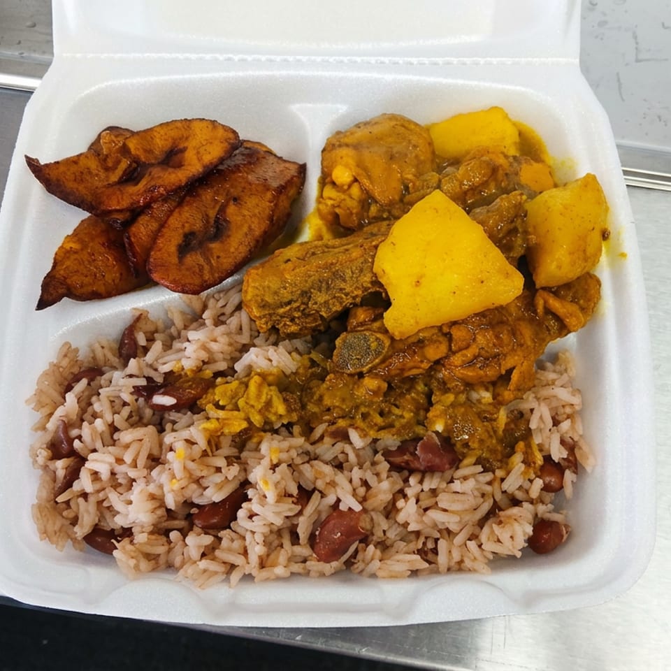 Takeout container filled with rice and beans, fried plantains, and yellow curry with vegetables and meat.